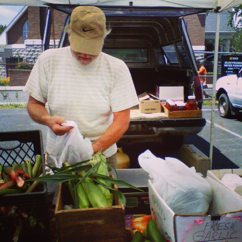 A man picks veggies at the St. George Greenmarket