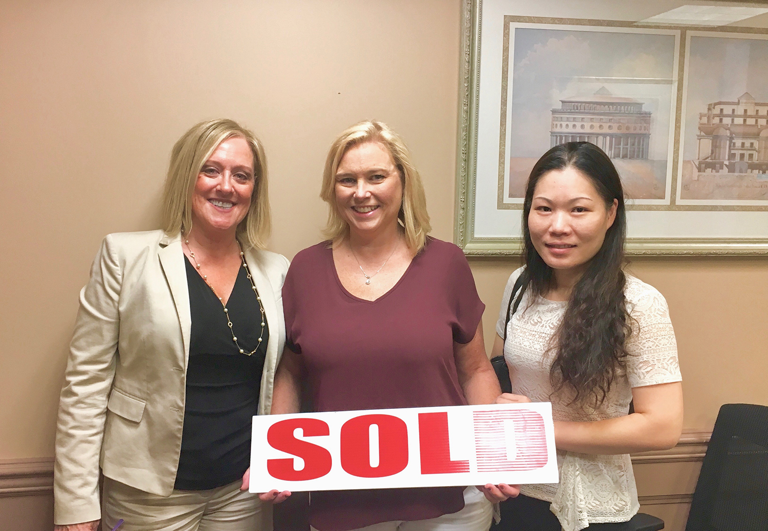 Photo of Happy Client, Rosemary, holding up a "sold" sign