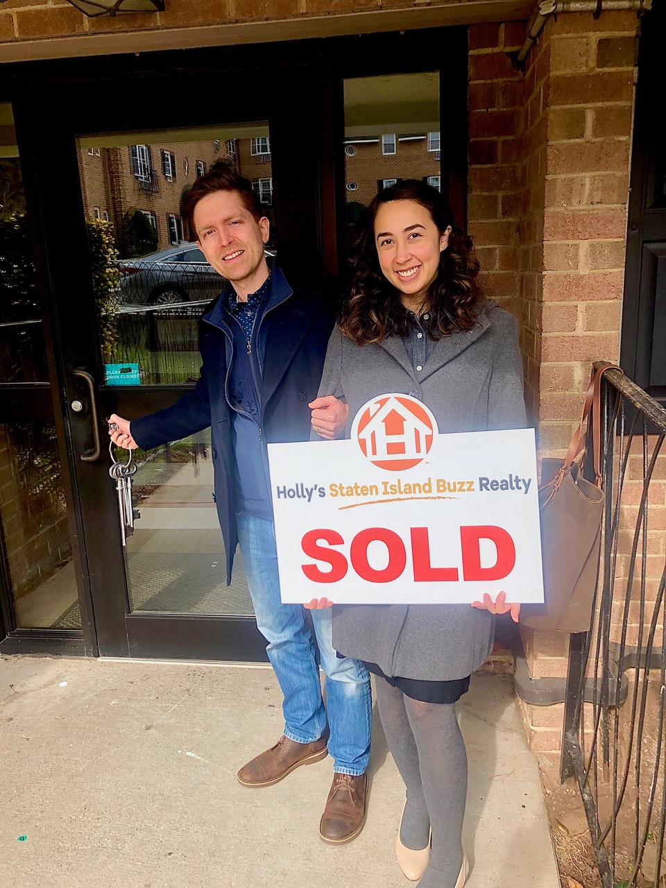 Deniz and Ron celebrating at the front door of their new home in Rosebank, Staten Island, after a successful home purchase with Holly’s Staten Island Buzz Realty.