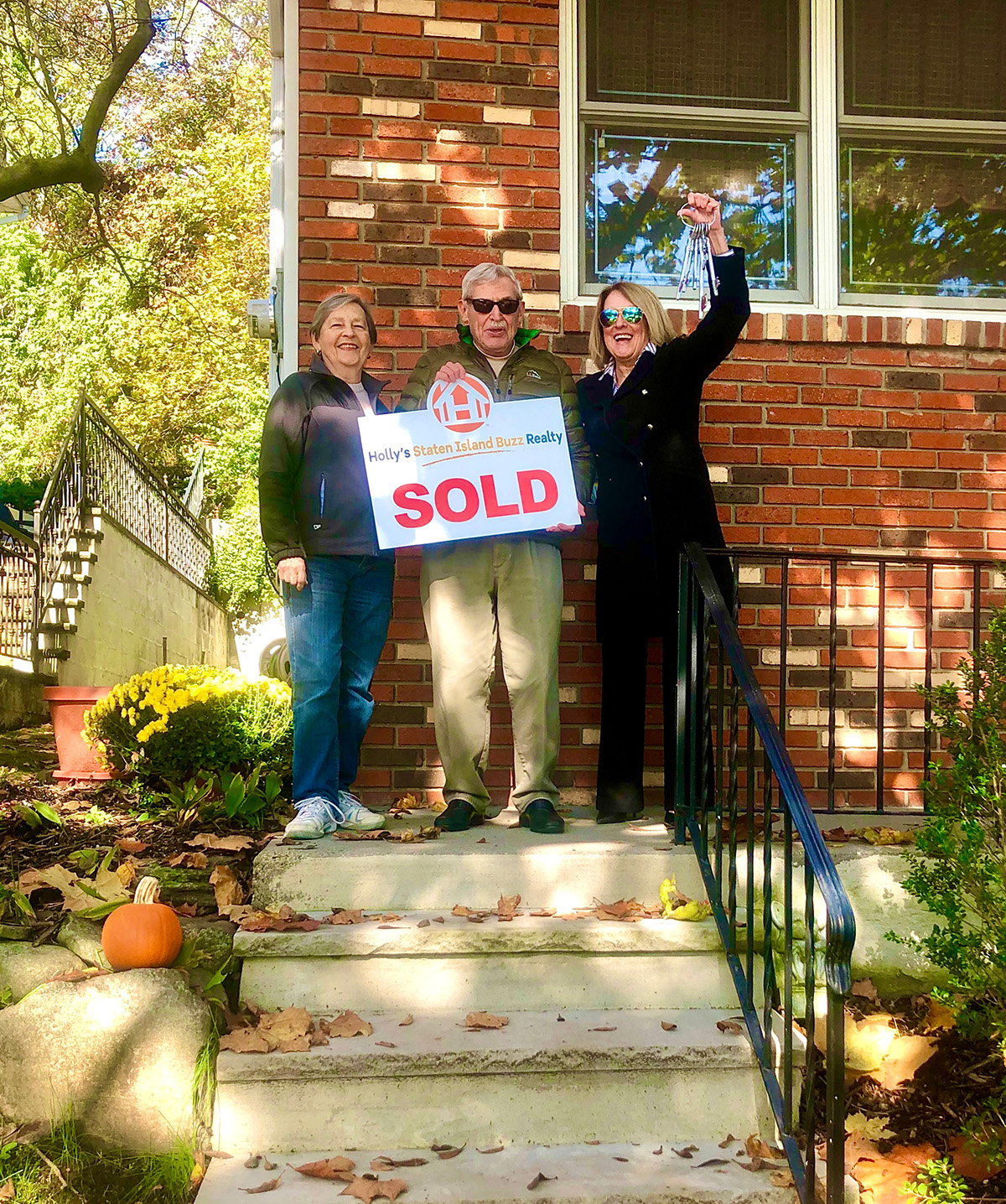 Myron and Ruth celebrating the sale of their Dongan Hills Colony home in Staten Island, NY with Holly’s Staten Island Buzz Realty holding a sold sign