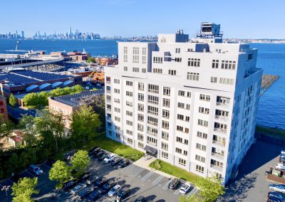 Aerial view of The Accolade Condominiums at 90 Bay St. Landing in St. George, Staten Island, overlooking New York Harbor and the Manhattan skyline.